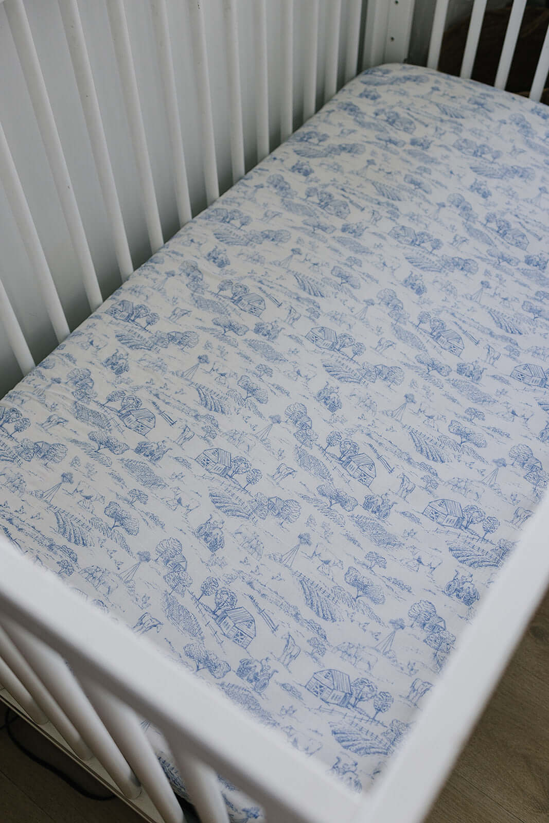 Farm Toile Muslin Crib Sheet | Transform your baby's crib into a cozy haven with our Farm Toile Muslin Crib Sheet. Crafted from our exclusive soft and breathable muslin fabric, this sheet showcases a neutral design that adds a touch of warmth and style to