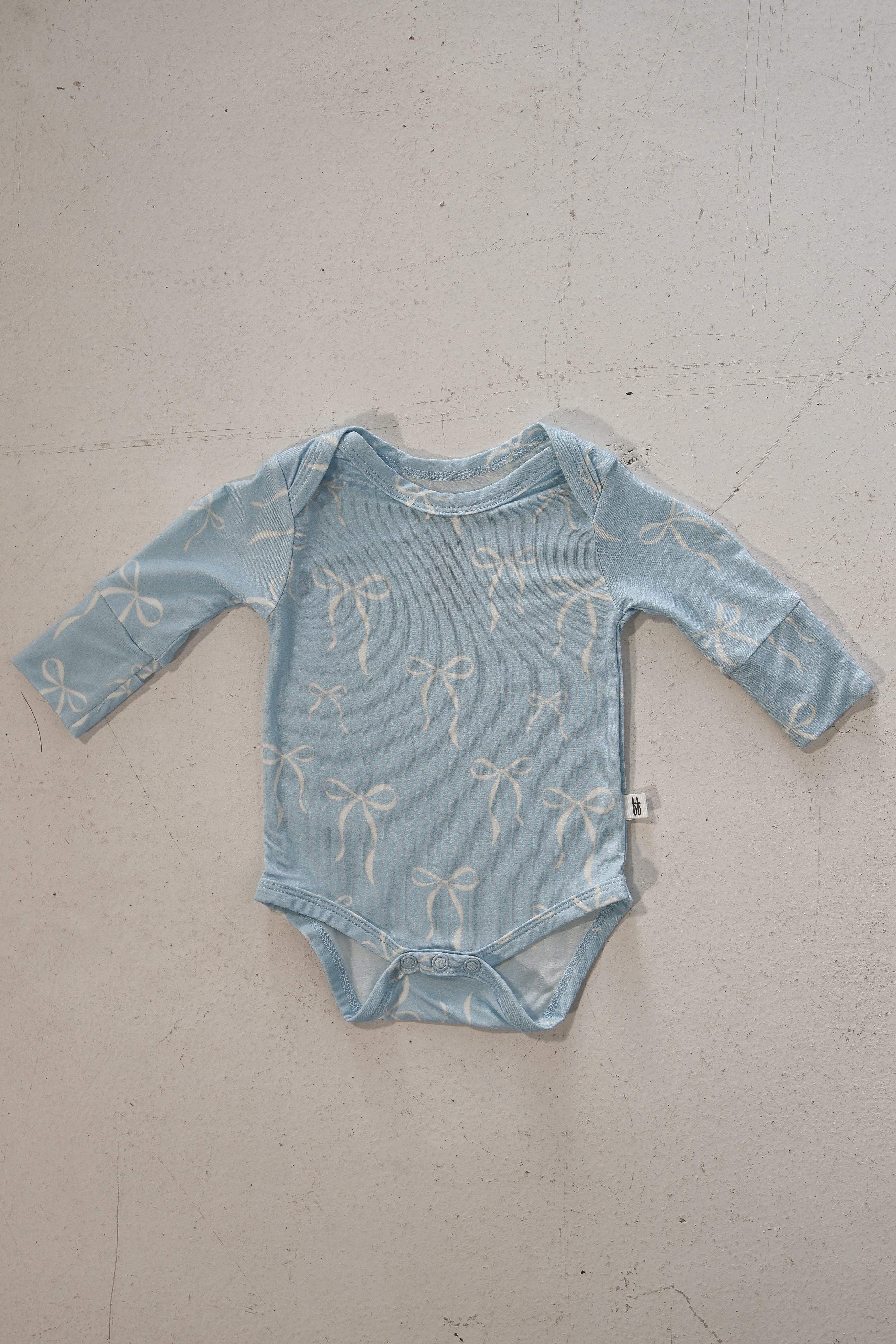 Blue Bows | Long Sleeve Bamboo Snapsuit | Made from the softest premium bamboo in our classic solid black, this snapsuit is cozy, durable, and easy to wear all day long. Designed for sleeping, playing, and everything in between, it features snap closures