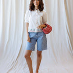 Model wearing Cherry Cute Button Down with puff sleeves, showcasing cherry embroidery and a stylish red bag.