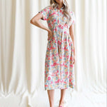 Woman wearing a Pleated Shirtdress with floral pattern, showcasing a collared neckline and kimono sleeves.