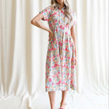 Woman wearing a Pleated Shirtdress with floral pattern, showcasing a collared neckline and kimono sleeves.