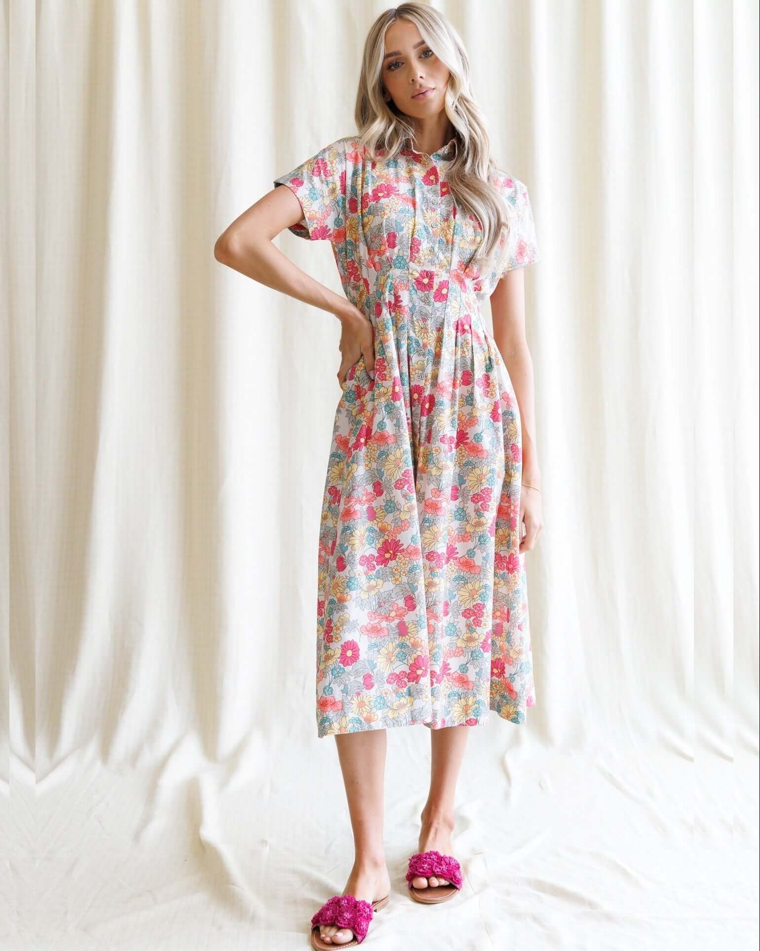 Woman wearing a Pleated Shirtdress with floral pattern, showcasing a collared neckline and kimono sleeves.