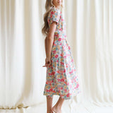 Model showcasing a Pleated Shirtdress with short sleeves, floral pattern, A-line shape, and perfect for milk & baby nursing needs.