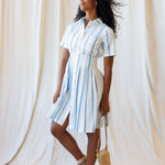 Model wearing the Seaside Stripe Dress, showcasing its pleated skirt and nursing friendly design for Milk & Baby.