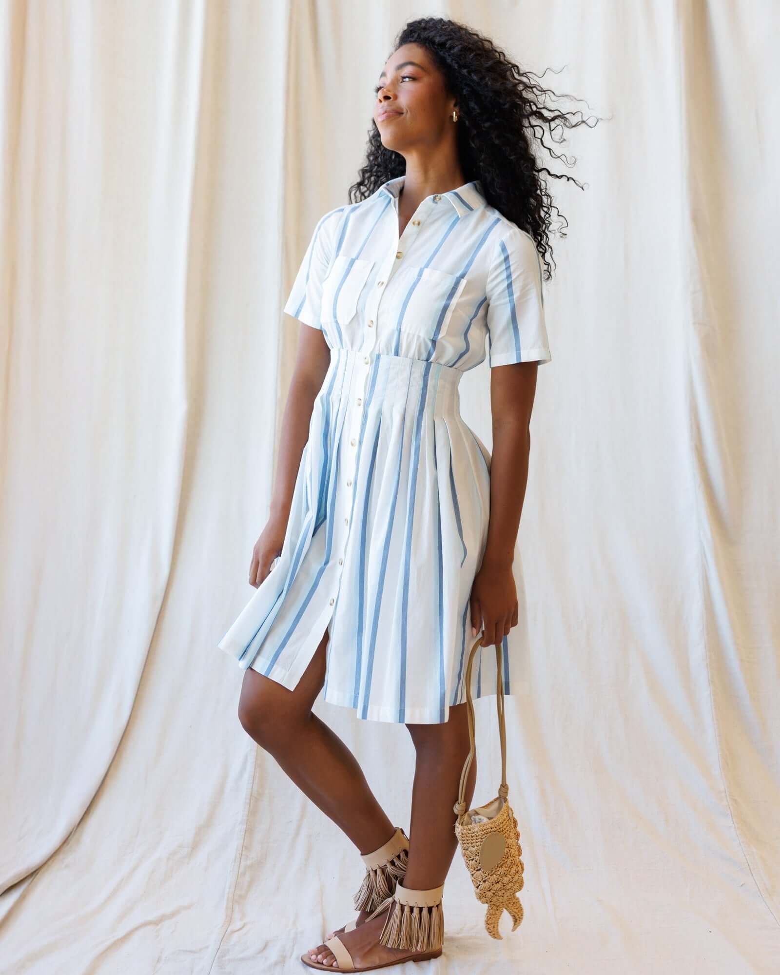 Model wearing the Seaside Stripe Dress, showcasing its pleated skirt and nursing friendly design for Milk & Baby.