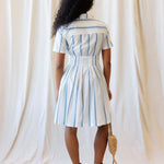 Back view of the Seaside Stripe Dress featuring a collared neckline, A-line pleated skirt, and nursing friendly design.