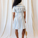 Back view of the Seaside Stripe Dress featuring a collared neckline, A-line pleated skirt, and nursing friendly design.