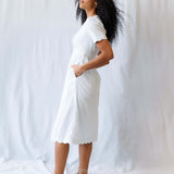Model wearing the Swiss Dot Scallop Dress, showcasing its short puff sleeves, pintuck bodice, and A-line midi design.