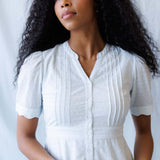 Model wearing Swiss Dot Scallop Dress with puff sleeves and pintuck details, perfect for nursing, stylish for Milk & Baby.