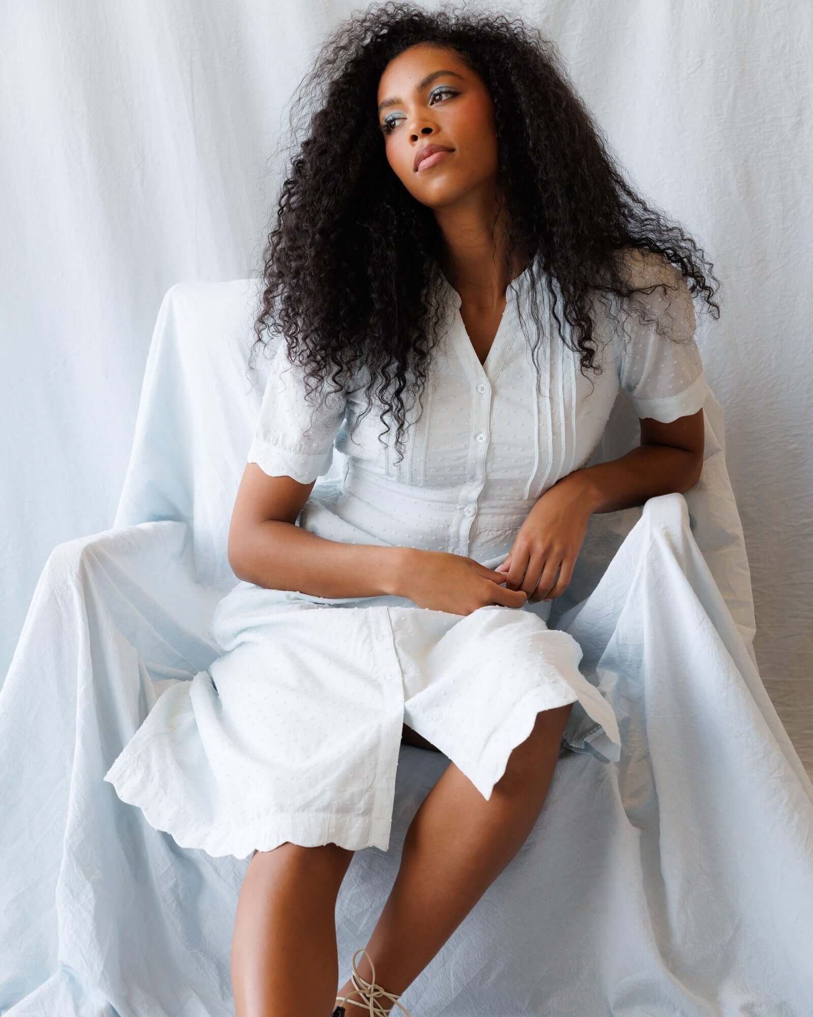 Model wearing the Swiss Dot Scallop Dress with puff sleeves, showcasing pintuck details and a relaxed style.