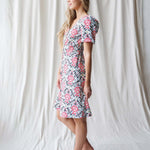 Stylish woman in Capri Dress with puff sleeves, V-neckline, and floral pattern, perfect for nursing friendly wear.