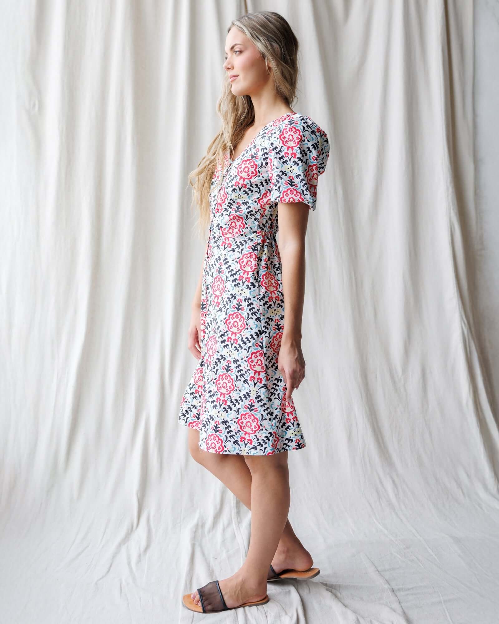 Stylish woman in Capri Dress with puff sleeves, V-neckline, and floral pattern, perfect for nursing friendly wear.