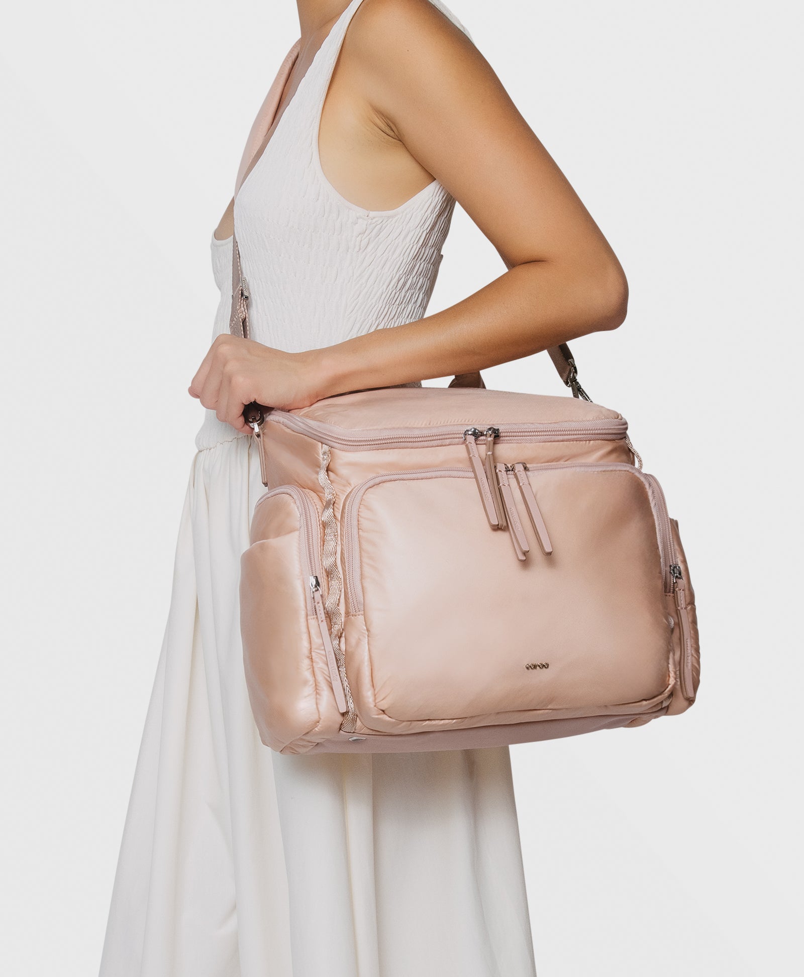 Caraa Baby Bag Medium in Blush Nylon carried by a model, showcasing its stylish design and practicality for parents.