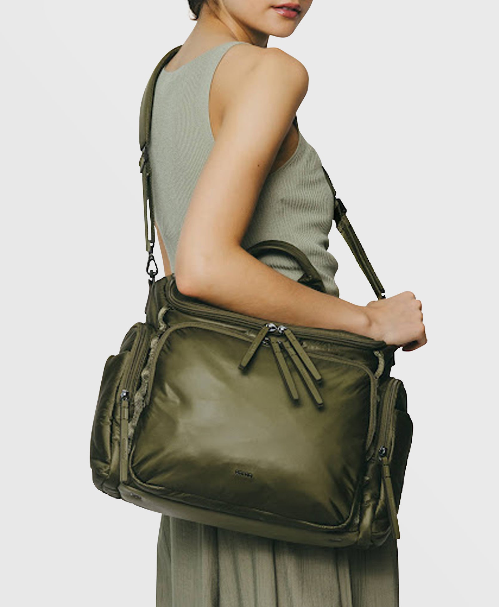 Caraa Baby Bag Medium in Olive Nylon worn by a woman, showcasing its stylish and functional design for parents.