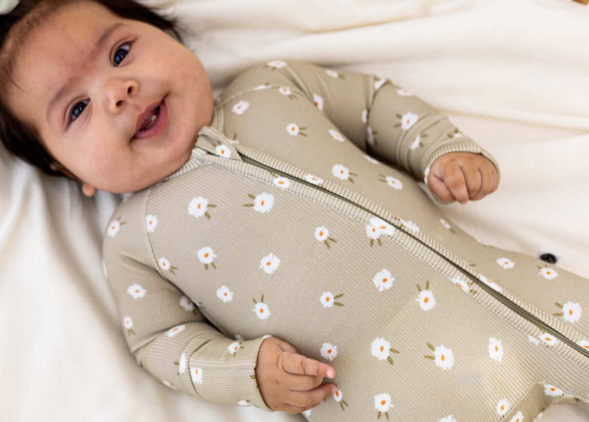 Baby wearing Sage Floral | Zip Romper made of soft bamboo, featuring floral prints and a double zipper for easy diaper changes.