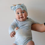 Blue Bows | Long Sleeve Bamboo Snapsuit | Made from the softest premium bamboo in our classic solid black, this snapsuit is cozy, durable, and easy to wear all day long. Designed for sleeping, playing, and everything in between, it features snap closures