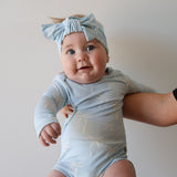 Blue Bows | Long Sleeve Bamboo Snapsuit | Made from the softest premium bamboo in our classic solid black, this snapsuit is cozy, durable, and easy to wear all day long. Designed for sleeping, playing, and everything in between, it features snap closures