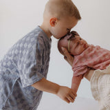 Two children interacting with each other on a plain background