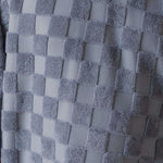 Close-up of a textured gray fabric with a checkered pattern