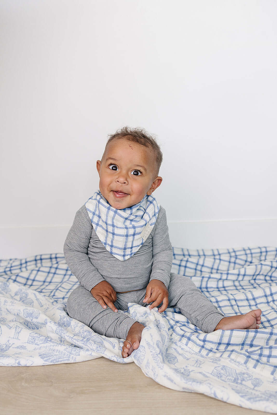 Farm Toile + Blue & Green Plaid Muslin Quilt | Indulge your little one in the cozy comfort of our Muslin Quilt. Crafted from the same fabric as our beloved muslin swaddles, this four-layer quilt offers warmth and softness for a restful sleep. Our neutral