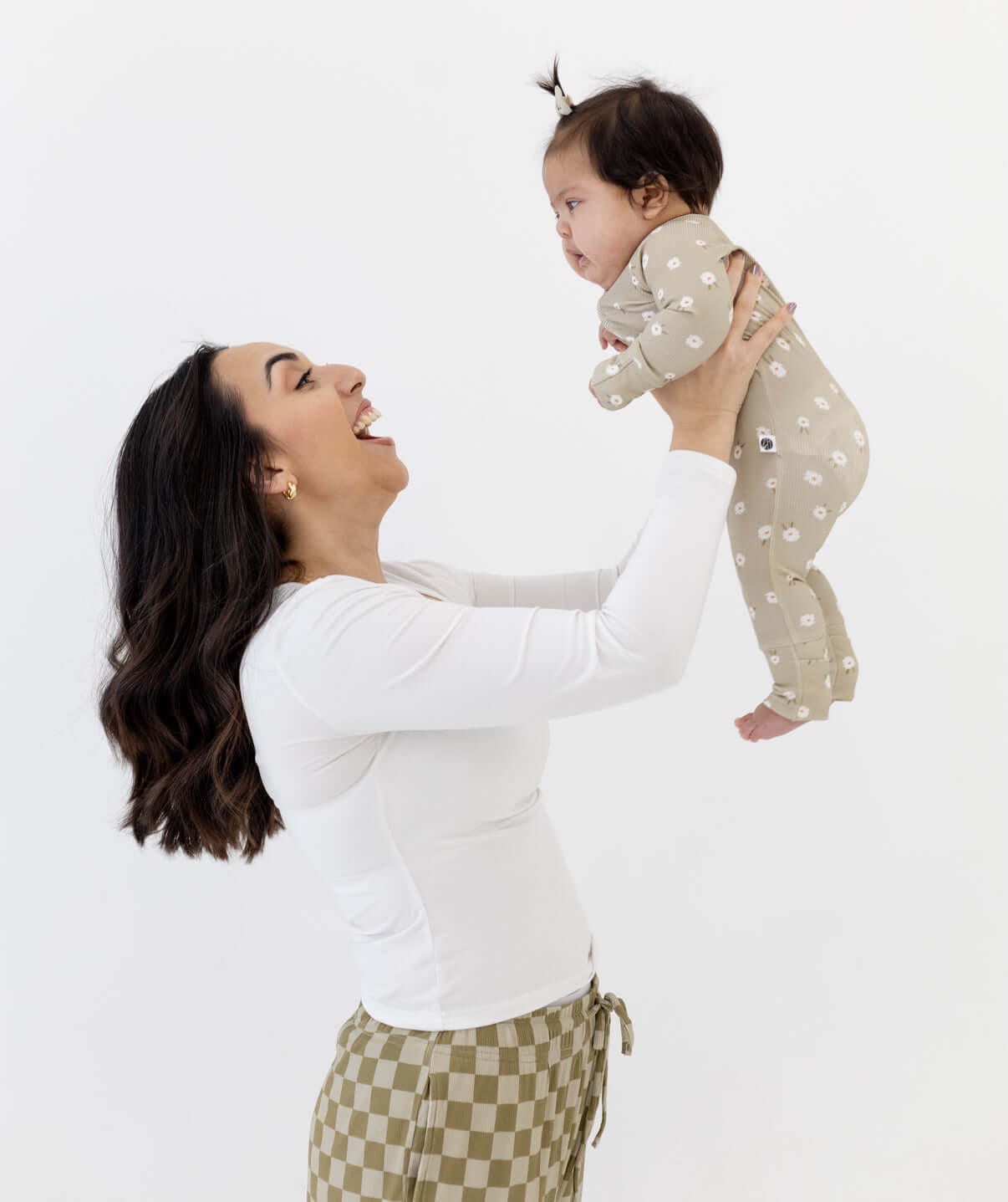 Mom joyfully lifting her baby wearing the Sage Floral | Zip Romper, showing off its soft design in action.