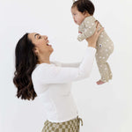 Mom joyfully lifting her baby wearing the Sage Floral | Zip Romper, showing off its soft design in action.