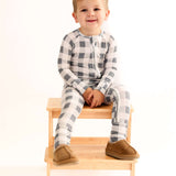 Slate Gingham | Zip Romper on a happy child sitting on a wooden stool, showcasing soft bamboo comfort.