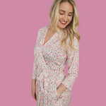 Woman in Blooms & Bows Women’s Dream Robe with floral print on pink background, smiling and showcasing a comfortable fit.