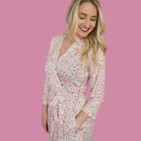 Woman in Blooms & Bows Women’s Dream Robe with floral print on pink background, smiling and showcasing a comfortable fit.