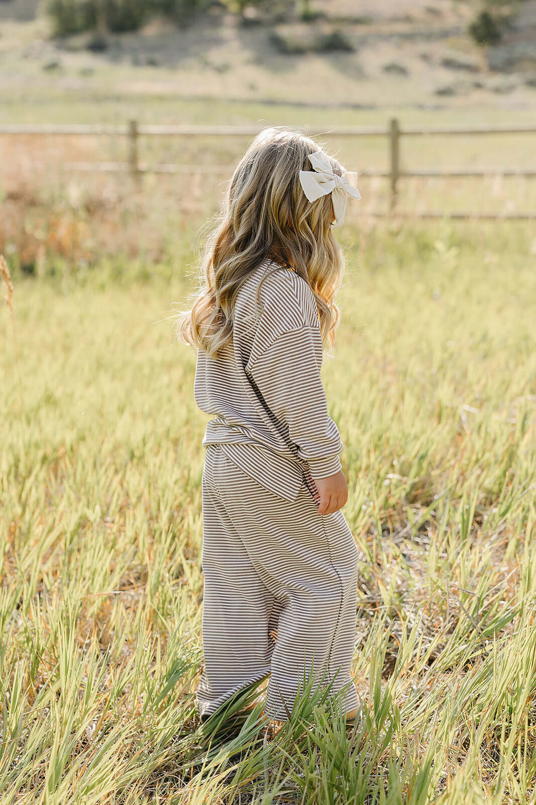 Child in striped loungewear set playing in a field, enjoying comfort and style | Striped Loungewear Set | Babies & Kids.