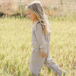 A happy child in a striped loungewear set running through a field, perfect for cozy playtime | Striped Loungewear Set | Babies & Kids.