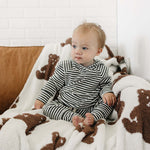 Adorable baby in the Charcoal Stripe Ribbed Hooded Set sitting on a cozy blanket with teddy bears.