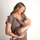 Smiling woman in ribbed cocoa brown Labor & Delivery Gown holding her baby.