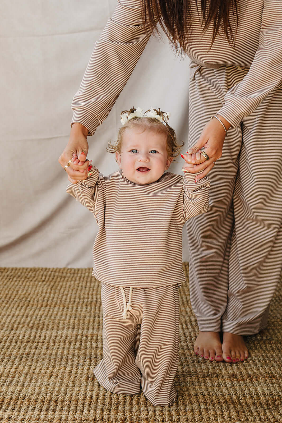 Baby in a Striped Loungewear Set | Babies & Kids, smiling while held by a parent in matching outfit.