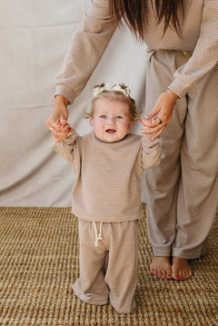 Baby in a Striped Loungewear Set | Babies & Kids, smiling while held by a parent in matching outfit.