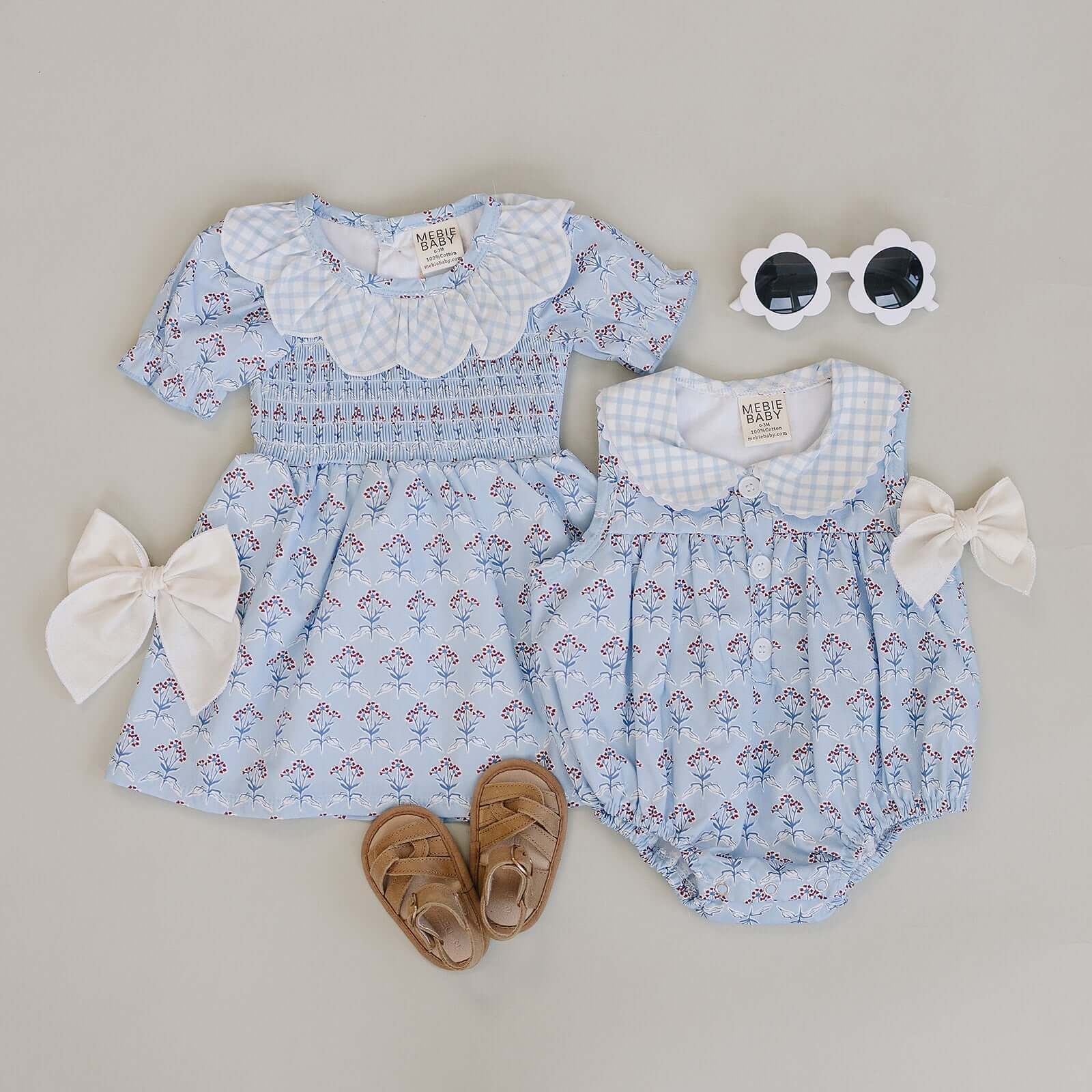 Blue Meadow Bubble Romper in light blue with red flowers, perfect for sunny days and playful adventures.
