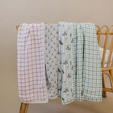 Tee Time + Green Gingham Muslin Quilt | Indulge your little one in the cozy comfort of our Muslin Quilt. Crafted from the same fabric as our beloved muslin swaddles, this four-layer quilt offers warmth and softness for a restful sleep. Our neutral colors