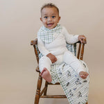 Tee Time + Green Gingham Muslin Quilt | Indulge your little one in the cozy comfort of our Muslin Quilt. Crafted from the same fabric as our beloved muslin swaddles, this four-layer quilt offers warmth and softness for a restful sleep. Our neutral colors
