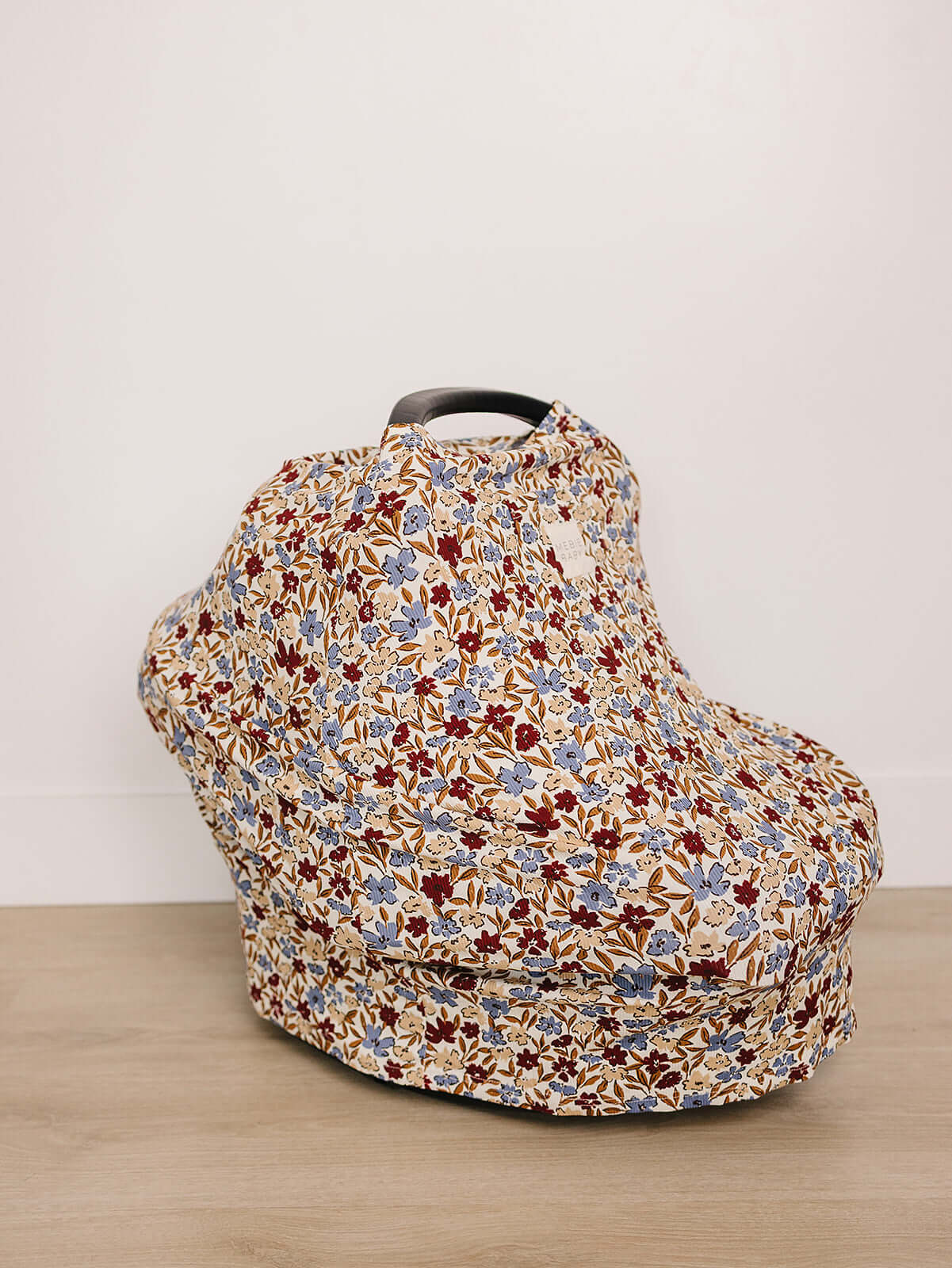 Desert Floral Ribbed Bamboo Multi-Use Cover on a car seat, showcasing its beautiful floral design.