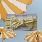 Sunny | Bamboo Head Wrap | Milk & Baby | Made from silky-soft bamboo material, this adjustable head wrap features a sweet bow for added style. Perfect for babies and toddlers!One size fits most Print: Sunny (a solid pale yellow) Material: 95% bamboo visco