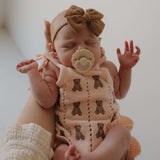 Lottie | Knit Ruffle Romper worn by a baby, featuring teddy bear embroidery, ruffles, and a bow | milk & baby