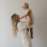 Woman holding a child against a plain background