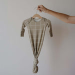 Baby onesie with plaid pattern on a hanger against a plain background