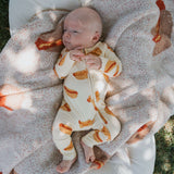 Model wearing Hot Dogs | Bamboo Zip Pajamas, cozy and cute, laid on a blanket outdoors.