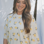 Woman wearing a light blue shirt with lemon pattern outdoors