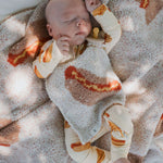 Baby sleeping in cozy Hot Dogs | Bamboo Zip Pajamas with matching blanket, showcasing soft bamboo fabric.