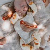 Baby sleeping in cozy Hot Dogs | Bamboo Zip Pajamas with matching blanket, showcasing soft bamboo fabric.