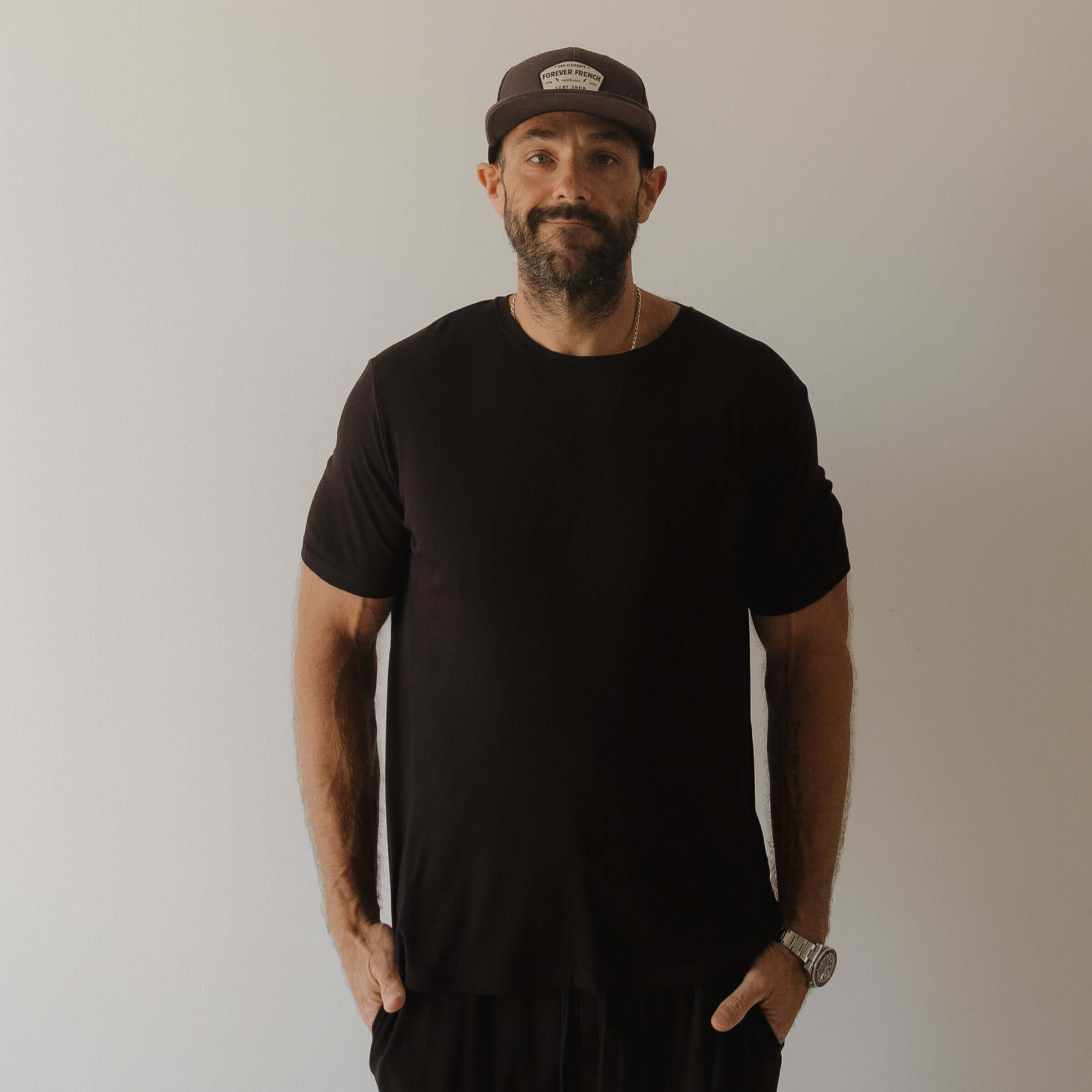Man wearing a black pajamas and cap against a plain background