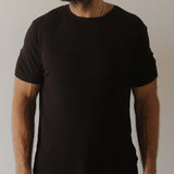 Person wearing a plain black pajamas against a neutral background
