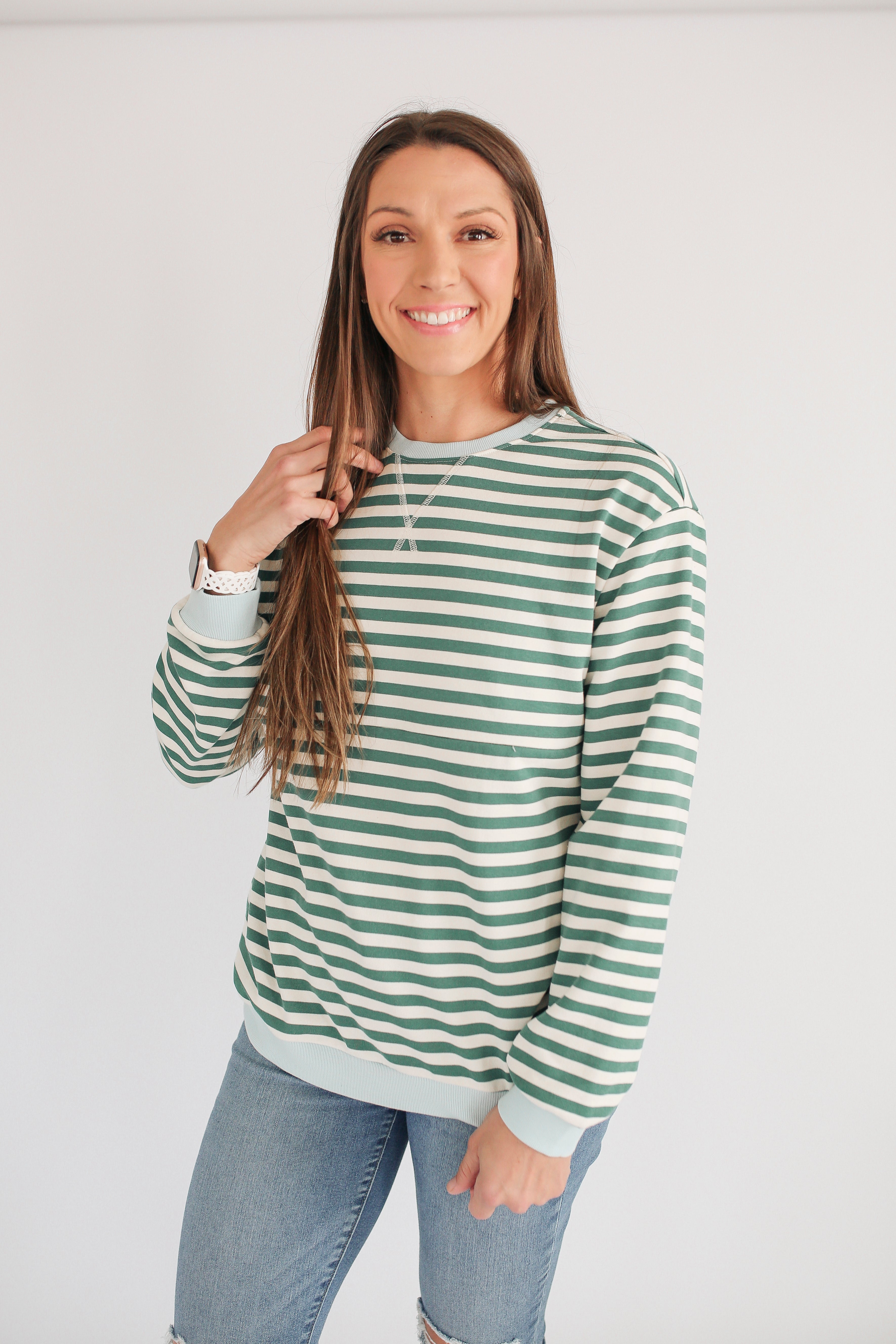 Woman smiling in an oversized fit freestyle stripe breastfeeding sweatshirt, perfect for breastfeeding moms.